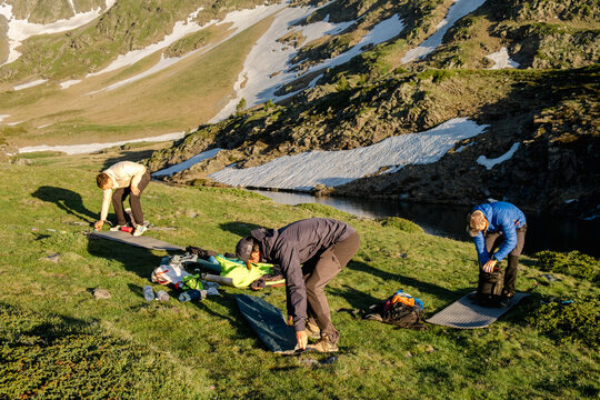 UGC Friends packing mountain bivouac camp at sunrise in Pyrenees