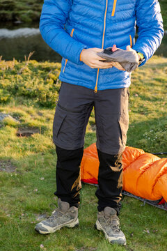 Anonymous man packing camping gear at sunrise in Pyrenees