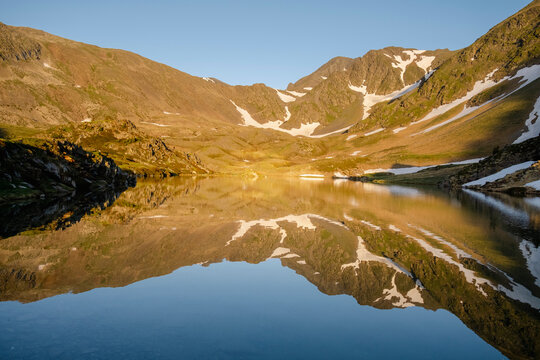 Sunrise reflection on alpine lake in the Pyrenees mountains