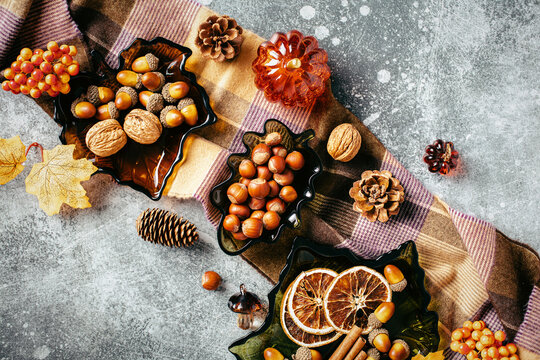 Autumn diagonal composition with nuts, spices and plaid blanket.