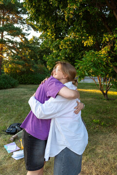 Two students embracing outdoors in park during golden hour