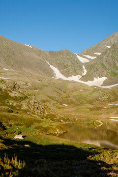 Morning light over alpine lake and bivouac tent in Pyrenees