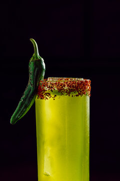 Spicy green cocktail with chili rim and jalape&ntilde;o garnish
