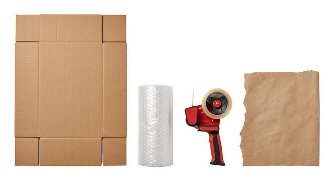 Flat lay of packing materials including a cardboard box, bubble wrap roll, tape dispenser, and brown craft paper