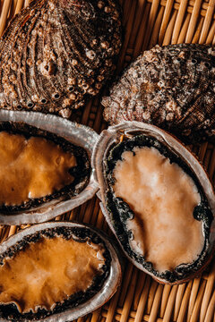 Close-up of raw fresh abalone inside a woven bamboo basket
