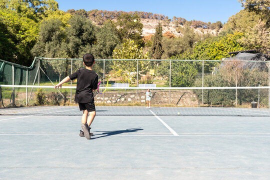 Playing Tennis on a Sunny Day at a Park With Friends