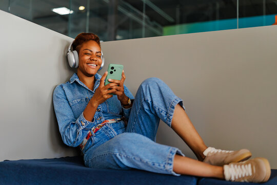 Women with short ha enjoying digital content with headphones and phone