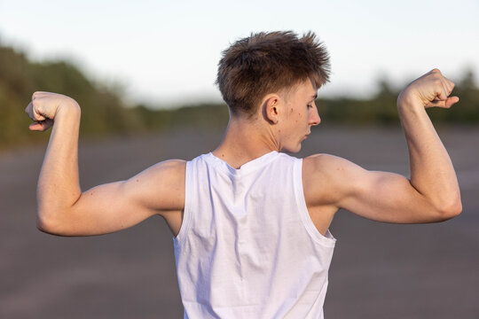 Teenage boy flexing his muscles