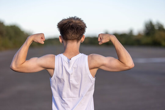 Teenage boy flexing his muscles
