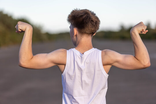 Teenage boy flexing his muscles