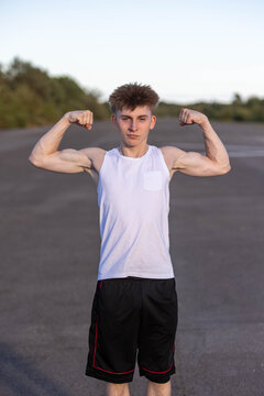 Teenage boy flexing his muscles