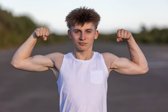Teenage boy flexing his muscles