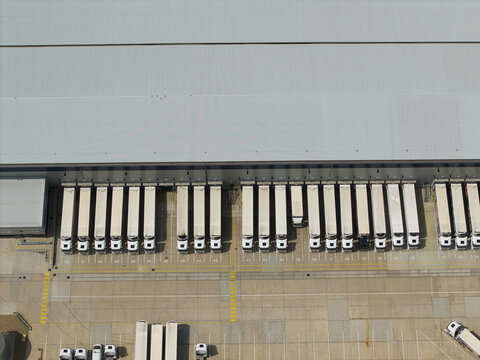 Aerial view of a large distribution centre with rows of parked HGVs and trailers at loading bays in Hemel Hempstead, England, United Kingdom.