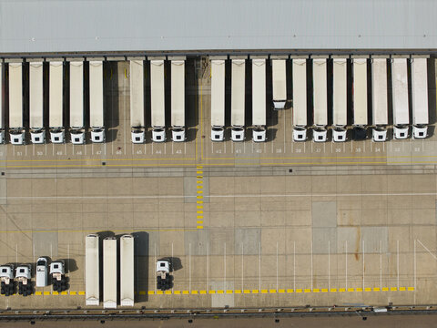Aerial view of a distribution centre with numerous HGVs parked in loading bays and a large concrete yard in Hemel Hempstead, England, United Kingdom.