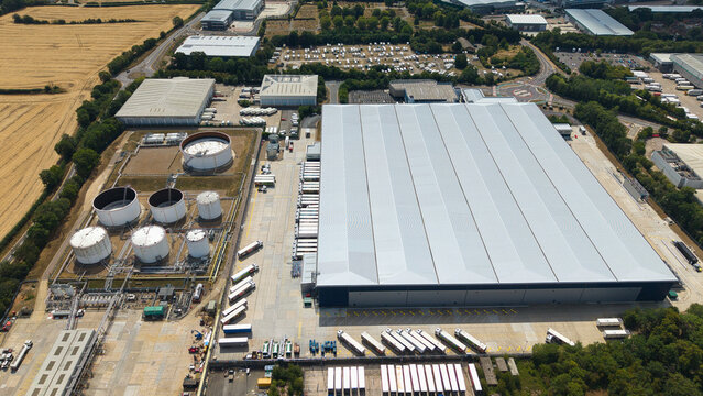 Aerial view of Buncefield Oil Depot and distribution centre with rows of parked HGVs and large storage tanks in an industrial landscape in Hemel Hempstead, England, United Kingdom.
