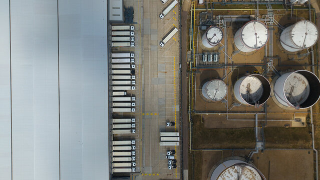 Aerial view of Buncefield Oil Depot and distribution centre featuring rows of parked HGVs and large industrial storage tanks in Hemel Hempstead, England, United Kingdom.