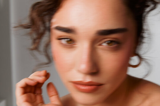Person With Curly Hair Touching Their Face