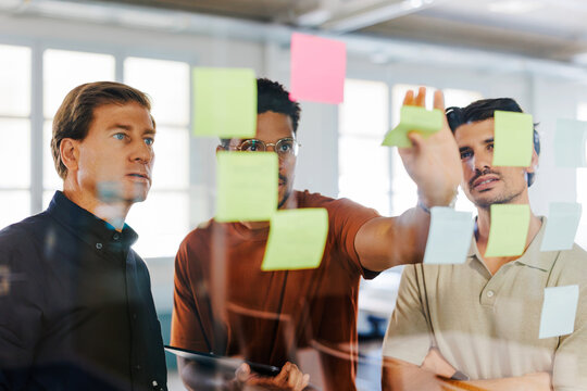 Men's group analyzing sticky notes working creative
