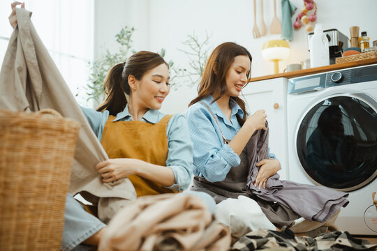 laundry teamwork women with friendship happiness; friends folding clothes together. laundry guides buyer choices, teamwork frames the scene, and women adds useful meaning. In a clear visual scene.