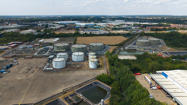 Aerial view of the petroleum oil terminal and LPG storage tanks in an industrial area with warehouses and surrounding greenery in Hemel Hempstead, England, United Kingdom.