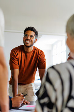 Creative man smiling during collaborative team meeting