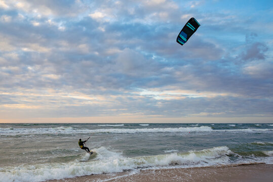 Kiteboarding sportsman rider with his kite in sea