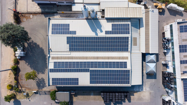 Aerial view of a paint manufacturing facility with extensive rooftop solar panels, highlighting industrial infrastructure and renewable energy generation in Milan, Lombardy, Italy.