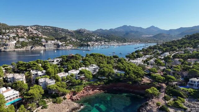 Aerial video of Port d'Andratx in Mallorca, Spain, featuring the harbor, marina, surrounding coastline, turquoise waters, boats and Mediterranean architecture, 4k.