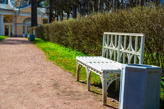 White bench sits beside gravel path