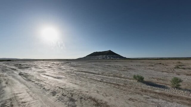 Scenic view from SUV driving on open terrain with mountain in the distance