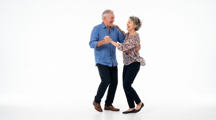 Fototapeta premium Joyful elderly couple dancing together with laughter and smiles on a white background