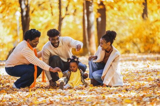 Three generations playing on the autumn grass