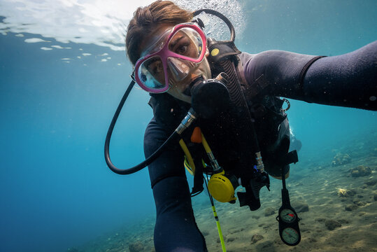 Caucasian Female Padi scuba diver instructor taking a selfie underwater