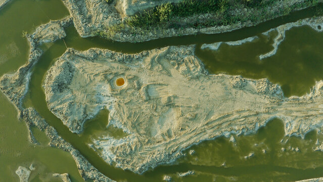 Aerial view of the Chibayish marshes featuring winding water channels cutting through sandy terrain and lush vegetation in Chibayish, Dhi Qar Governorate, Iraq.