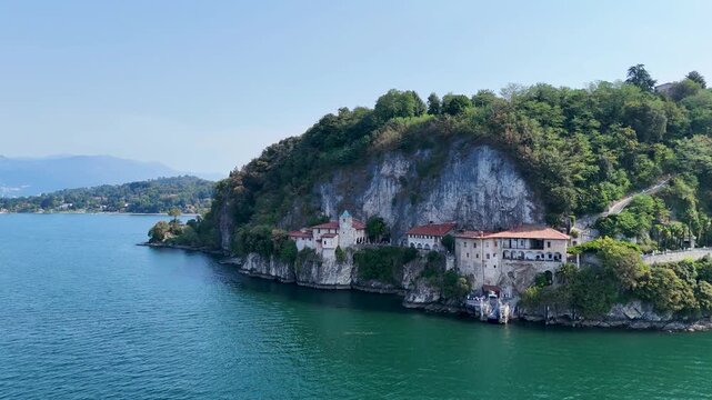 Santa Caterina del Sasso monastery on the shores of Lake Maggiore, Italy, showcasing its dramatic lakeside setting. Aerial 4K drone video footage of hermitage Eremo di Santa Caterina del Sasso