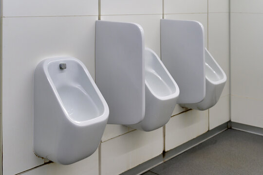 Close up row of urinals men public toilet
