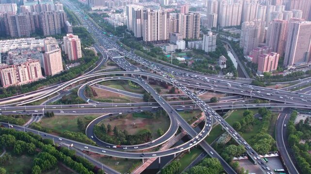 An aerial shot of a large, complex highway interchange surrounded by dense urban high-rise buildings.