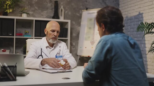 Physician writes prescription and gives medication to male patient at check-up