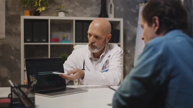 Doctor shows genetic data on laptop, educating male patient about DNA defects