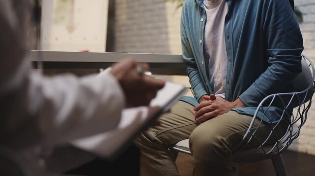 Man discusses men's health problem with urologist during check-up in clinic