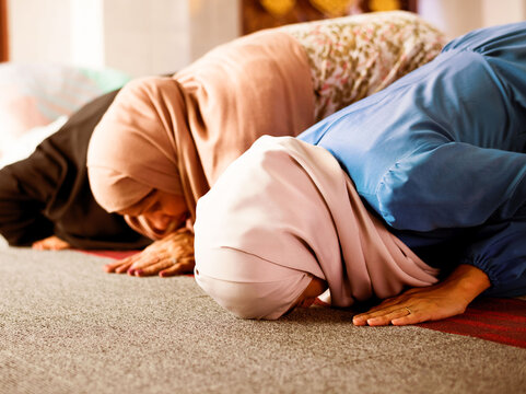 Women in prayer at mosque, embracing spirituality