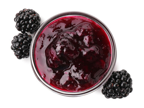 Delicious blackberry jam in glass bowl and fresh berries isolated on white, top view