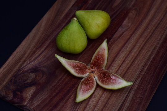 Fresh figs and a sliced fig on a wooden board