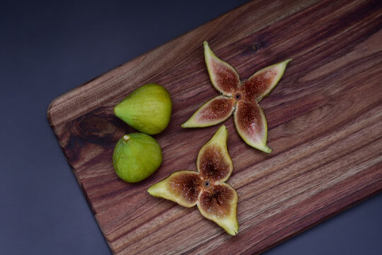 Fresh figs whole and sliced on a wooden serving board