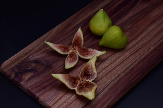 Fresh green figs whole and sliced on a serving board