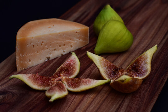 Cheese and figs served on a wooden board