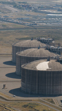 Aerial view of Dunkirk LNG Terminal featuring large industrial storage tanks surrounded by infrastructure and roads in Loon-Plage, Hauts-de-France, France.