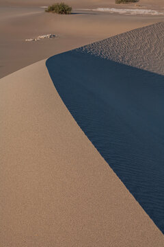 Beautiful vertical view of abstract sand dunes texture with curved shadow