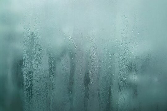Frosted glass condensation backdrop with soft turquoise highlights - A soft turquoise‑toned frosted glass backdrop accented by condensation highlights
