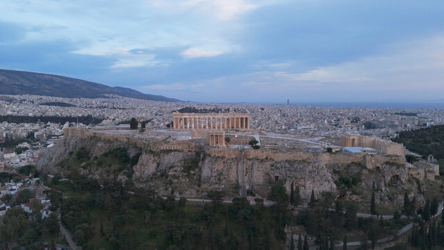 Aerial view of the historic Acropolis of Athens and the Parthenon temple situated on a rocky hill above the dense urban sprawl of Athens, Greece.
